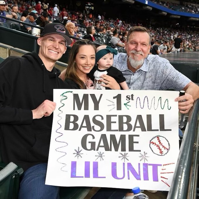 Randy Johnson poses with his granddaughter and family with a sign that says 