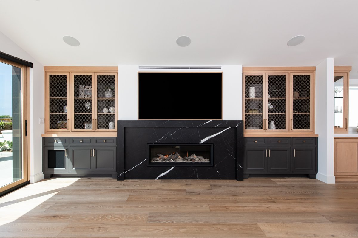 The two-tone cabinetry in this entertainment center pairs perfectly with the black marble fireplace.

📷: @leighannrowe
