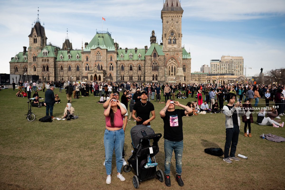 A person takes a selfie while wearing eclipse glasses during a #SolarEclipse on Parliament Hill in Ottawa, Monday, April 8, 2024. For @CanadianPress