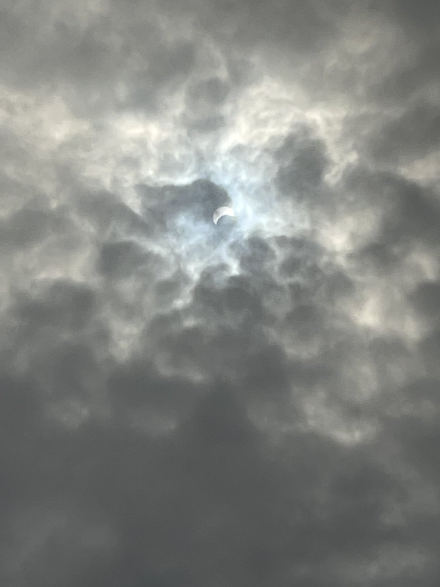 A once-in-a-lifetime “crescent sun” in a patch of blue sky, peaking among the overcast grey clouds…a symbol, and a prayer for a patch of peace among the turmoil, for all those who share this sun.