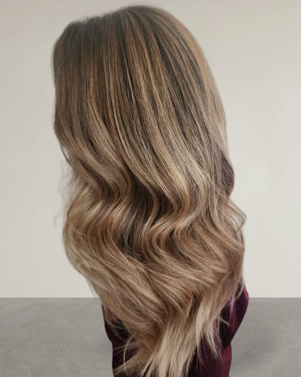 'Embracing natural roots with a hint of sun-kissed glow. #RootSmudge #Teasylights #Foilyage #HairTransformation'