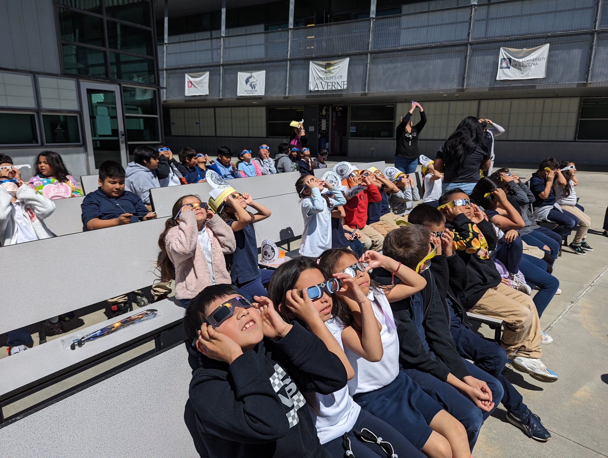 Student watching eclipse sitting on grass