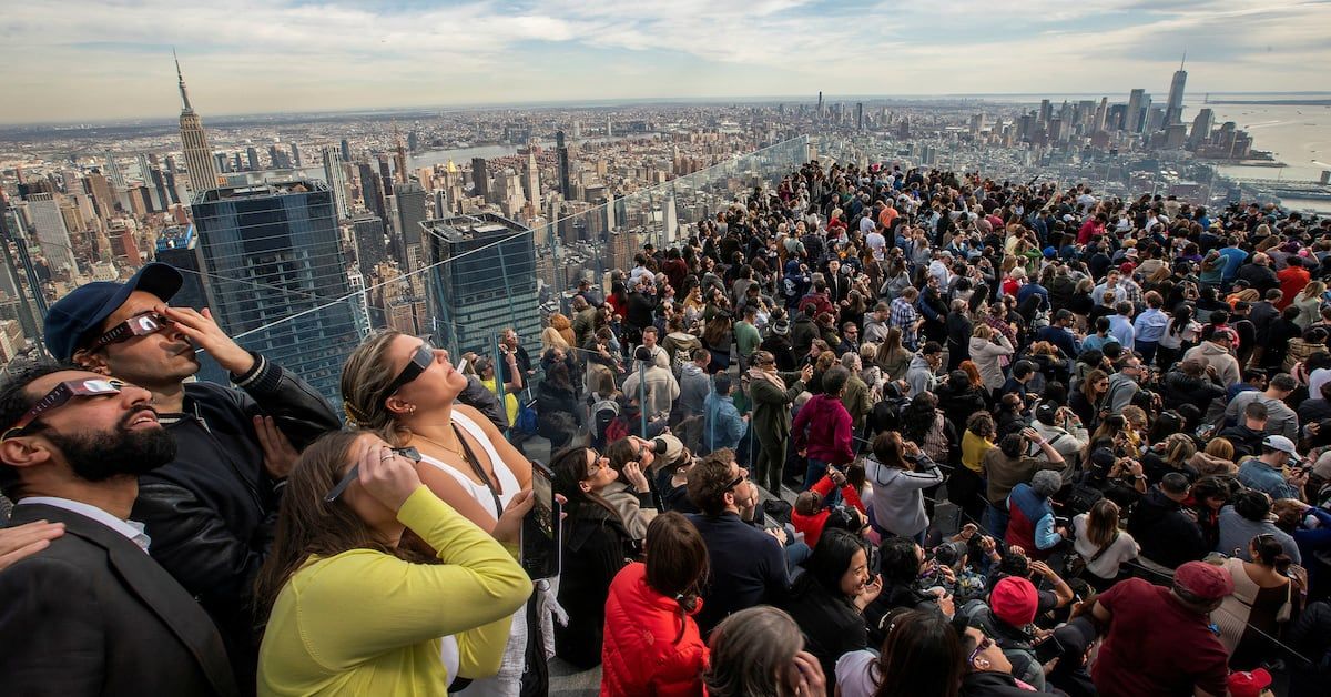 People watch the partial solar eclipse as they gather on the observation deck of Edge at Hudson Yards in New York City reut.rs/3TL2enQ