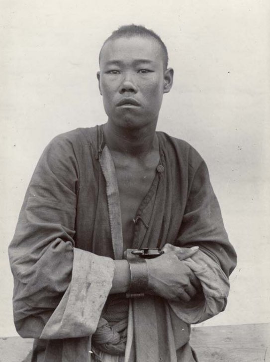 A Chinese criminal with handcuffs, Tsingtau青岛, ca. 1900.