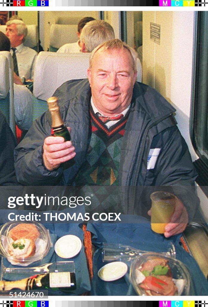 This file picture shows British truck driver Roy Clementson (R), the first heavy goods vehicle driver to make the undersea channel crossing with the Eurotunnel freight service, about to enjoy some champagne in the wagon reserved for HGV drivers (1994)