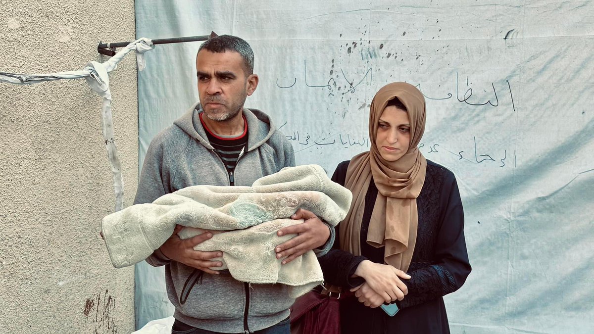 This morning, Adam Salem a Palestinian toddler died due to lack of necessary health care, according to his mother, after Israeli military evacuation order from the north to the south of Gaza and a struggle with illness. In the photo, his exhausted parents tell a heart-wrenching