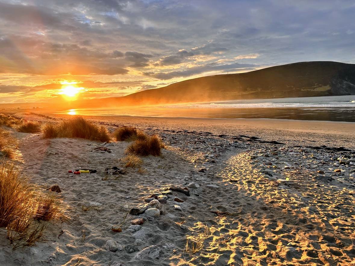 Whether you're strolling along the shore or simply taking in the breathtaking views, #Achill's charm captivates at every turn...we just love this image of a stunning #sunrise in Keel this week by Stephen Crowe 💛 #keelbeach #WildAtlanticWay #mayo #achillisland #AmazingAchill