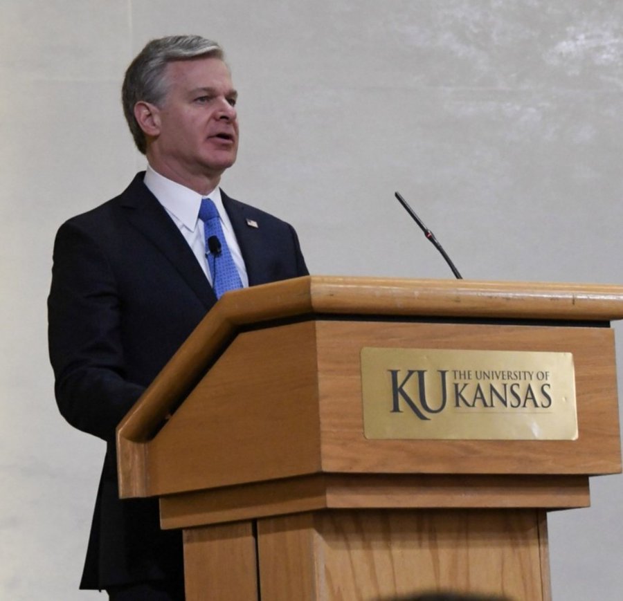 FBI DIrector Christopher Wray speaks at a podium at the University of Kansas.