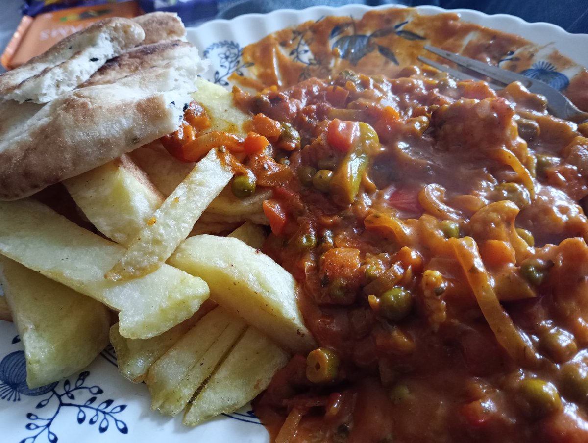 Vegetable tikka masala with chips and naan bread.