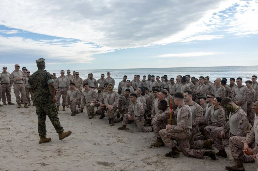 Marine Corps Lt. Col. Brian M. Carthon, the Commanding Officer for II MEF Support Battalion, and Marines with COMMSTRAT Company and MAGTF HQ pose with the trophy of the 2024 Annual Battalion Squad Competition on Onslow Beach at Marine Corps Base Camp Lejeune, North Carolina.@USMC