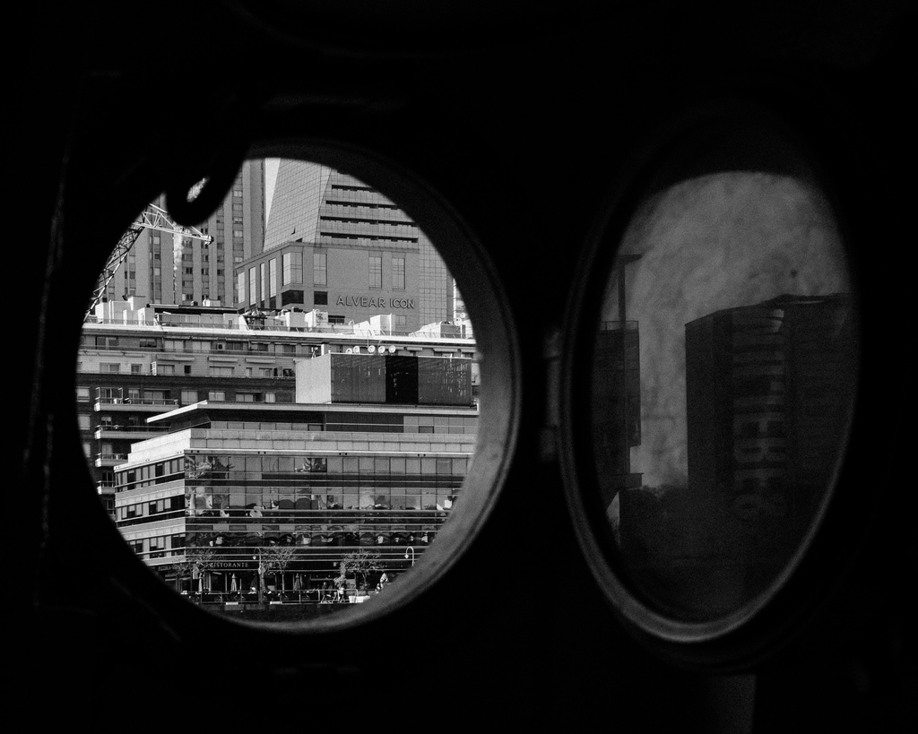 Framing urban life through a nautical lens – Buenos Aires as seen from a ship's porthole. 🛳️🏢 #UrbanView #PortholePerspective #BuenosAires #Cityscape #MonochromePhotography #ShipView #TravelMoments #ConcreteJungle