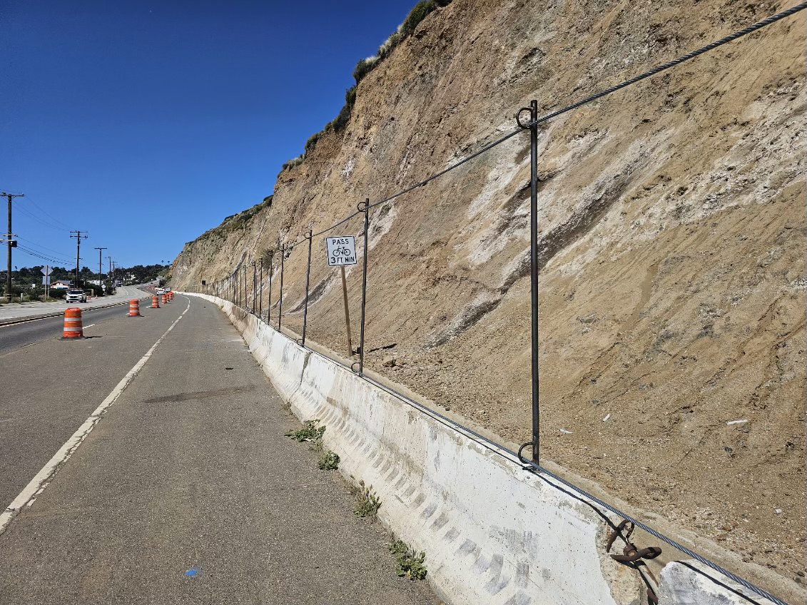 *Northbound PCH at Corral Canyon Road - Malibu* The right lane remains blocked on northbound State Route 1 as workers construct a 'rock fence' along the top of the existing K-rail to retain possible future slides. Please #BeWorkZoneAlert