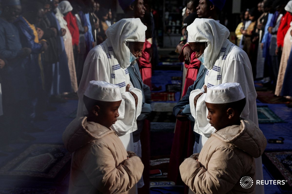 People pray outside the Masjid At-Taqwa mosque on the sidewalk, during Eid al-Fitr in the Bedford-Stuyvesant section of the Brooklyn borough of New York City. Photo by @ShannonStaplet2