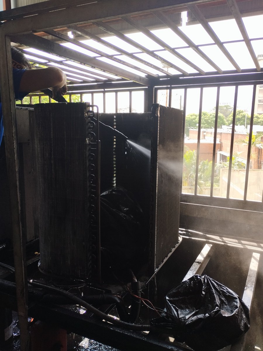 Realizando mantenimiento preventivo a unidades condensadoras de equipos de aire acondicionado de 5 Ton con hidrojet.