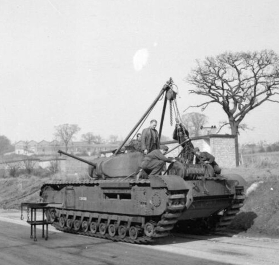 'Changing the engine of a Churchill tank using an 'Atherton jack', at the Royal Army Ordnance Corps workshops at Mill Hill in London, 15 March 1942.' That's the caption for this image found on Alamy. You can see sawtooth outline of the army facilities in the distance.