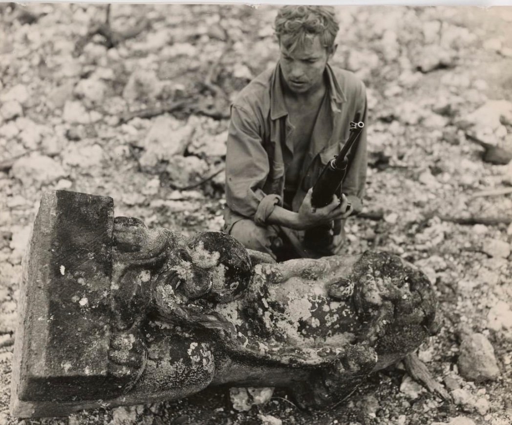 In 1945, a Marine with the 1st Marine Division examines an Okinawan idol found in the courtyard of Shuri Castle during the Battle of Okinawa. 🪖