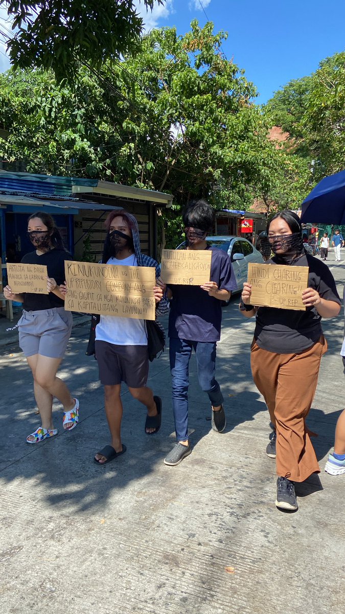 LOOK: Students form a barricade along the streets of Area 2 in UP Diliman to bar the report of second clearing operations by the Quezon City local government in the area today. This comes a few hours after the clearing team confiscated vending articles without prior notice.