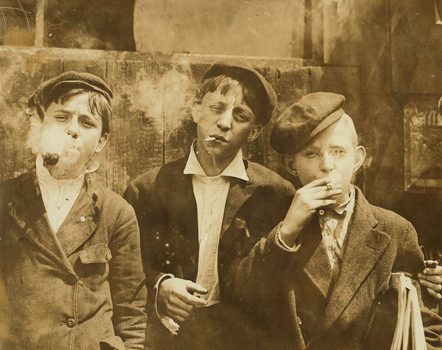 11:00 A. M . Monday, May 9th, 1910. Youg newsies (News boys) all smoking at Skeeter's Branch, St. Louis, Missouri. Photo source: Library of Congress/Hine, Lewis Wickes; National Child Labor Committee