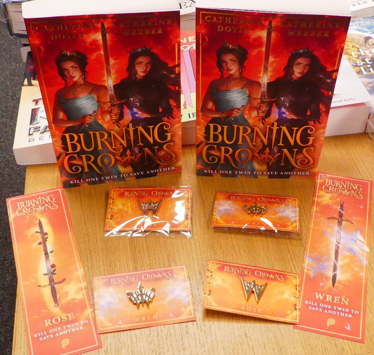 Out this week, Burning Crowns from @doyle_cat and @kwebberwrites is the third in the Twin Crowns trilogy. We have free double-sided bookmarks and Rose and Wren badges! Free with in-store purchase only. #ChooseBookshops