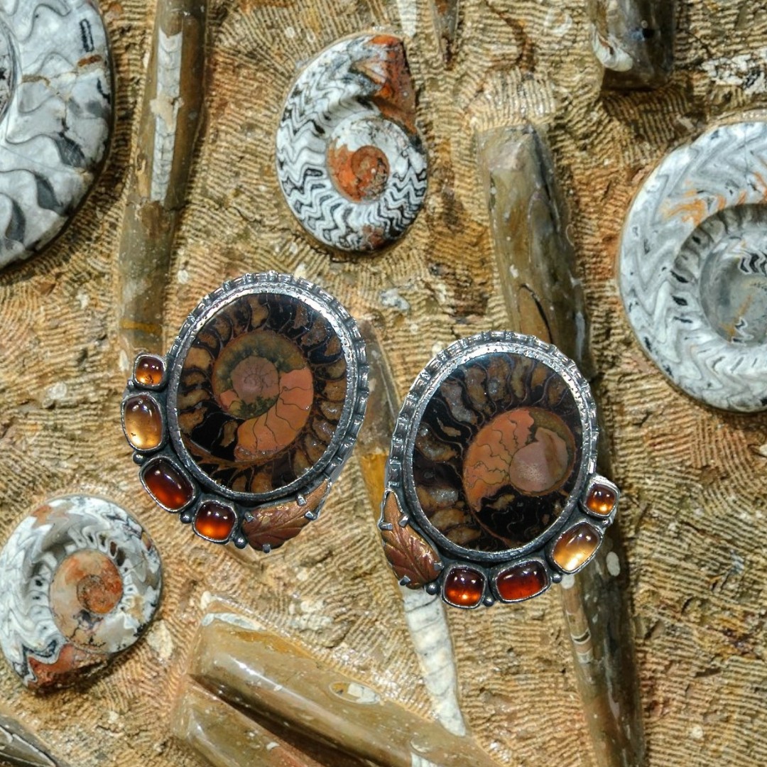 These ammonite fossil earrings are a rare find! Surrounded in garnets and hessonite! A perfect pair! #fossil #earrings #gemstone  #AmmoniteFossil #RareFind #FossilJewelry #GemstoneEarrings #StatementJewelry
