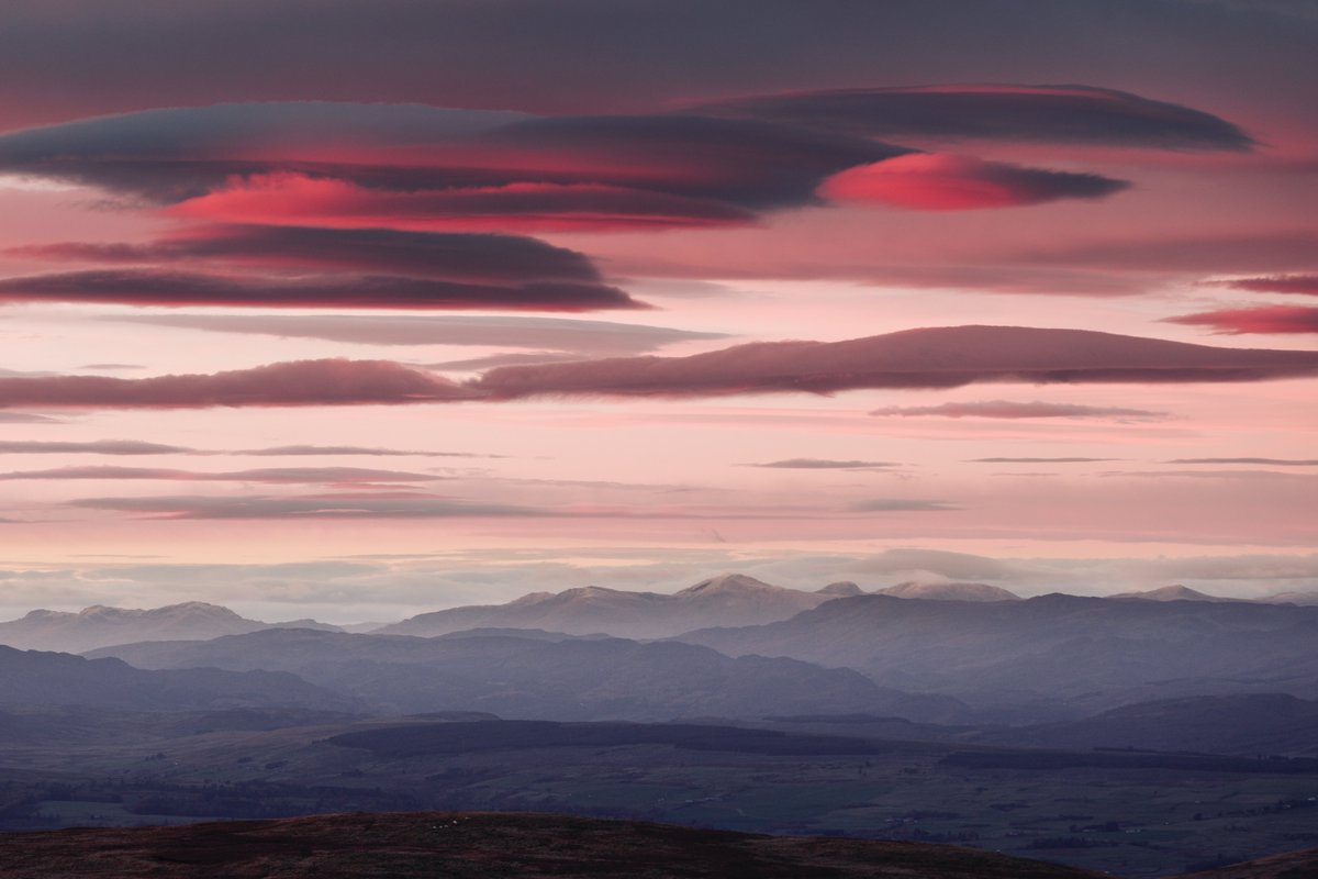 A photo I took recently of lenticular clouds at sunset on the top of Ben Cleuch, looking towards Ben Lawers. Lenticular means 'double convex lens', referencing the shape. How lenticular clouds form As air encounters a mountain, it's forced upwards. This rising air cools due to