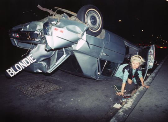 'Car Crash Debbie' - Bob Gruen's portrait of Debbie Harry, taken at a wrecked car on 6th Avenue and 50th Street in New York City, 1976