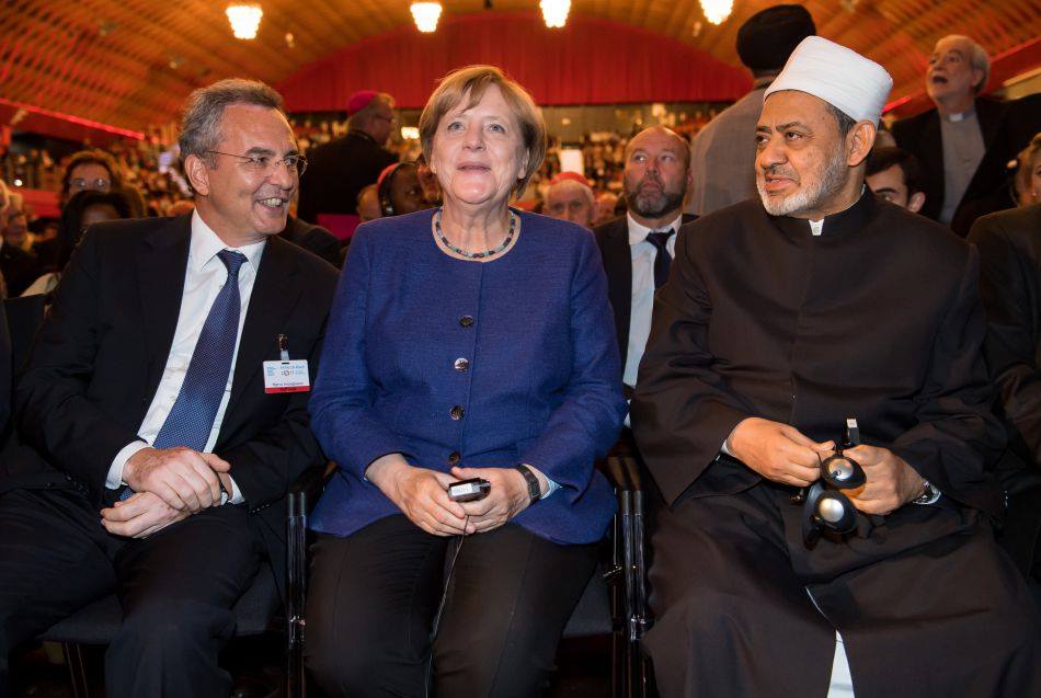 Der Scheich al-Azhar (hier rechts auf dem Foto beim Evangelischen Kirchentag neben Merkel) gilt als der einflussreichste Theologe im sunnitischen Islam, der der Al-Azhar Universität in Kairo vorsteht. Nachdem der Islam-Appeaser Haldewang behauptet hat, dass der muslimische