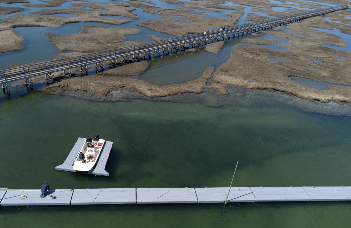 Another sign of spring on a chilly April morning, Town of Yarmouth crews install the dock and boat slips at Gray's Beach in Yarmouth Port against a backdrop of the boardwalk. @capecodtimes