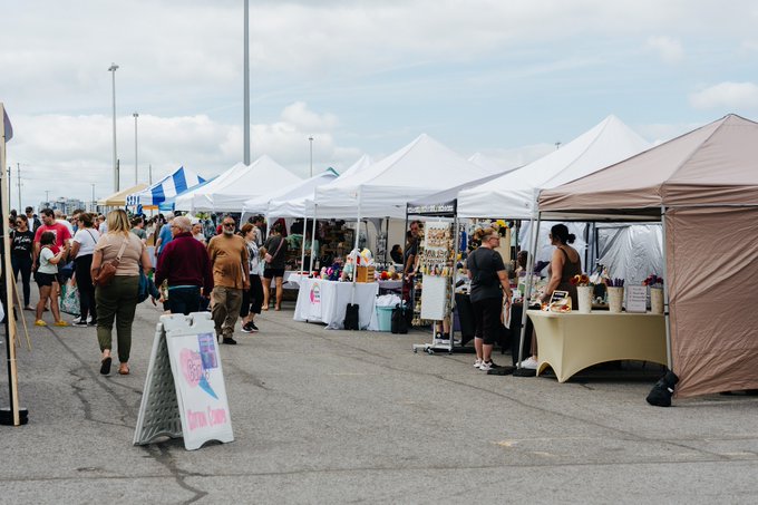 Des personnes flânent parmi les kiosques des exposants au marché de producteurs de Barrhaven.