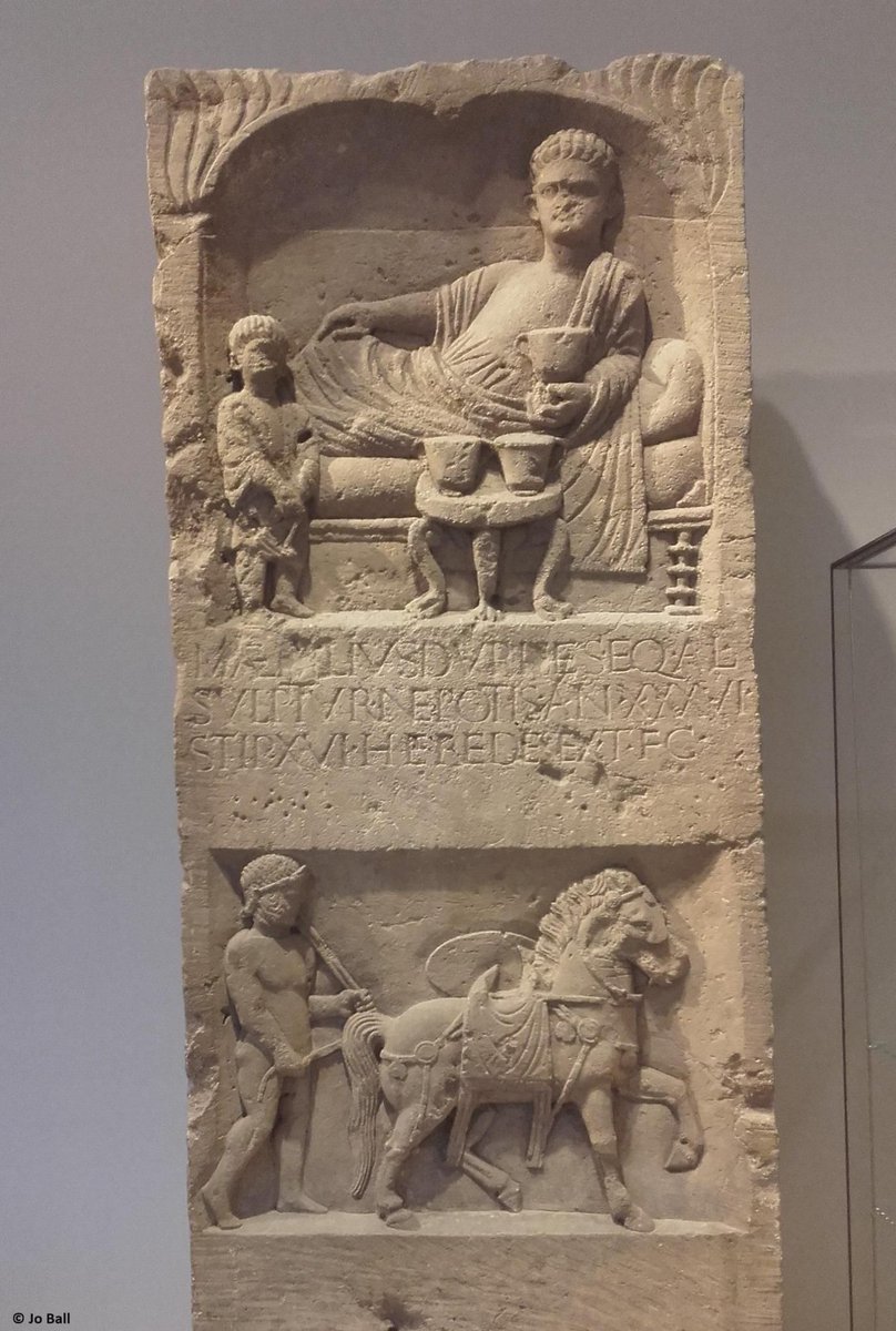 This is the tombstone of Marcus Aemilius Durises, a Roman cavalry trooper. Two scenes are seen: one of Durises lying on a dining couch, and another most likely depicting him and his horse. In AW XVII.2, Jo Ball explains all about this tombstone: buff.ly/4aYiZ6a