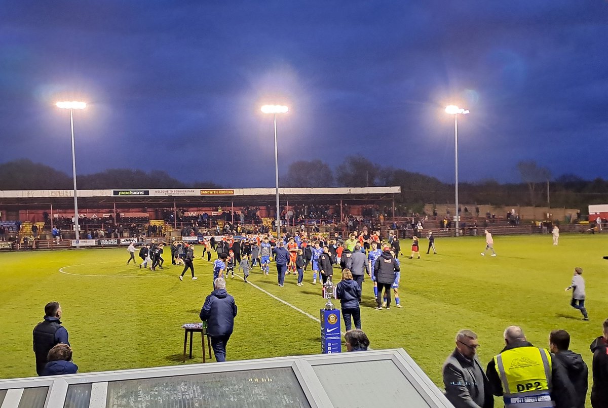 A mini pitch invasion by young fans greets Workington's victory over Carlisle United in the Fred Conway Cumberland Cup final