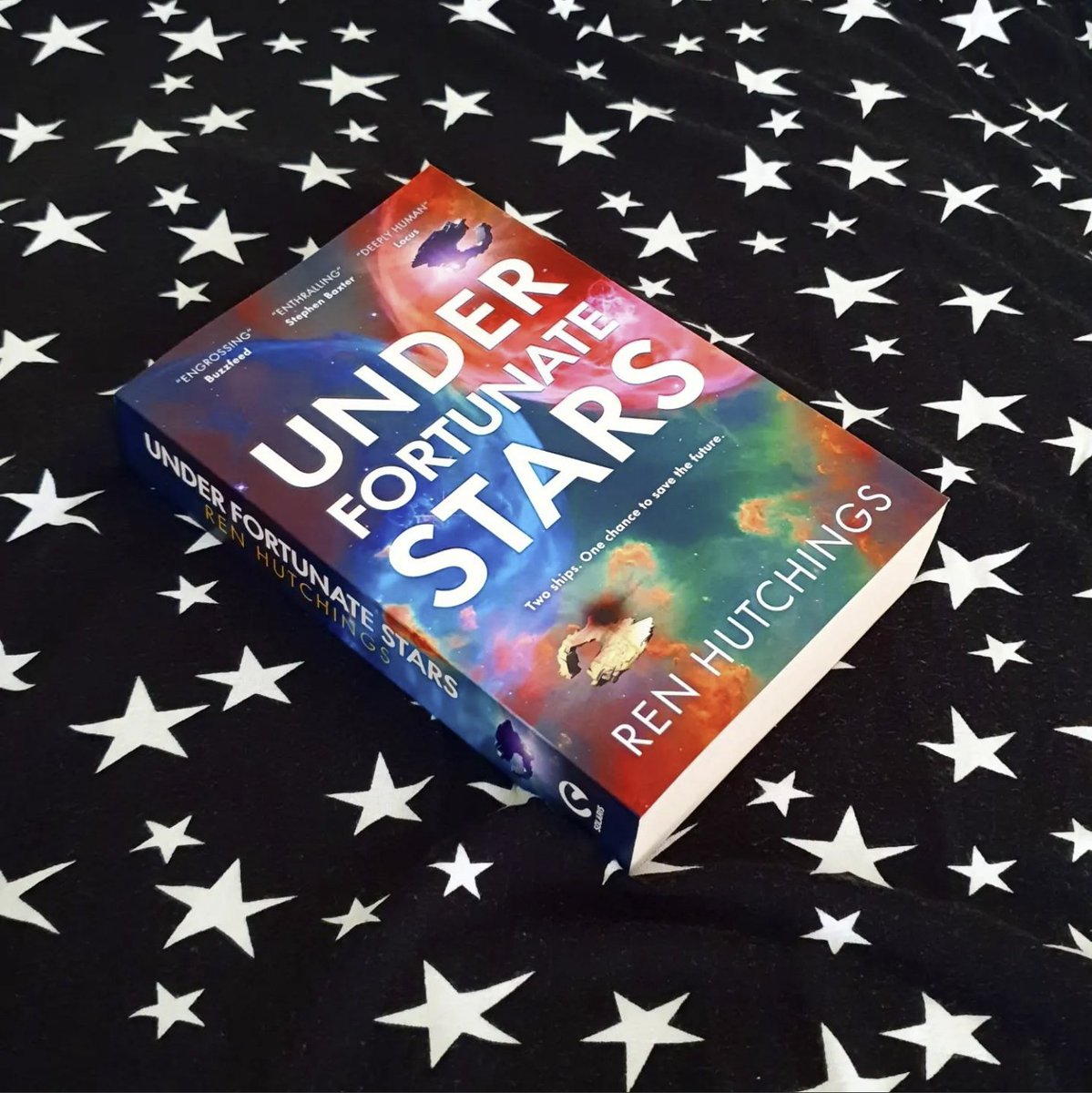 Never meet your heroes... unless you're stuck in a time rift with them 🌠 For fans of Becky Chambers and Firefly, @voidcricket's hopeful space opera, UNDER FORTUNATE STARS, is out now in paperback! ➡️ bit.ly/3MSihOR