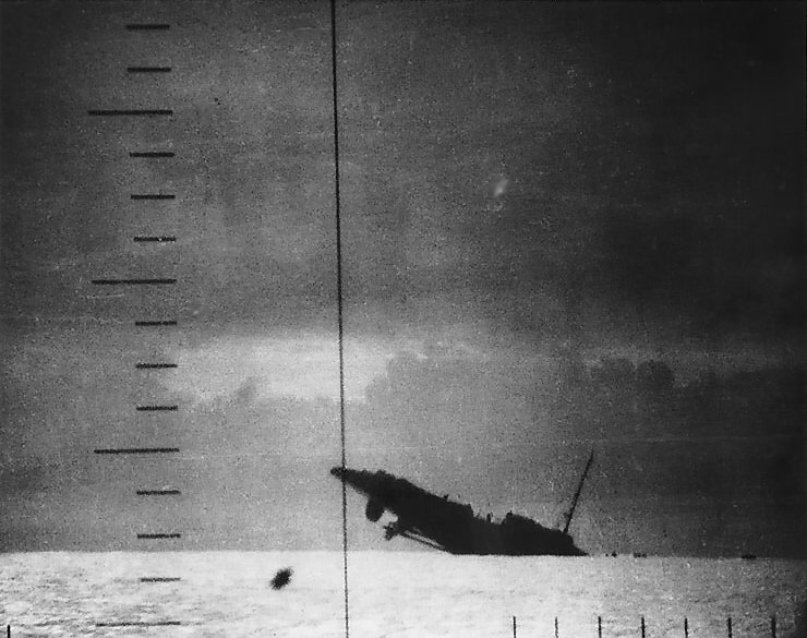 Japanese Patrol Boat #39 sinking after being torpedoed by American submarine Seawolf, 23 Apr 1943; seen from Seawolf's periscope