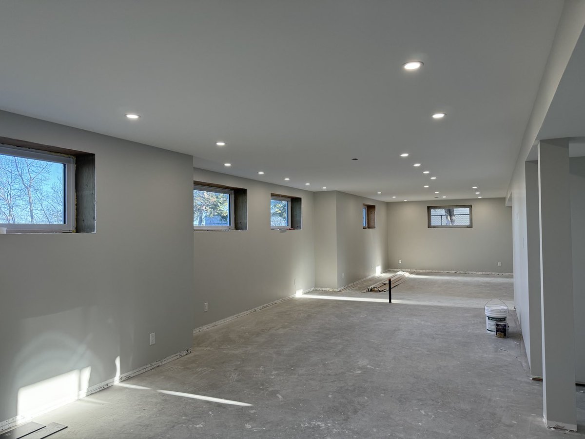 Kitchen pendant lights are up, living room fan, stairwell light and basement pot lights are in. Next, basement flooring.