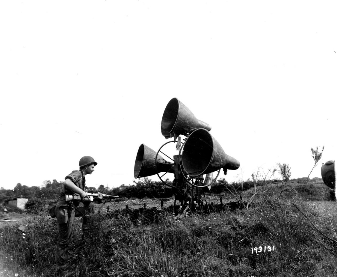 In August of 1944, Pvt. Don Doornkaat of the 6th Armored Division moves in on a German aircraft listening device outside near Brest, France. 🪖