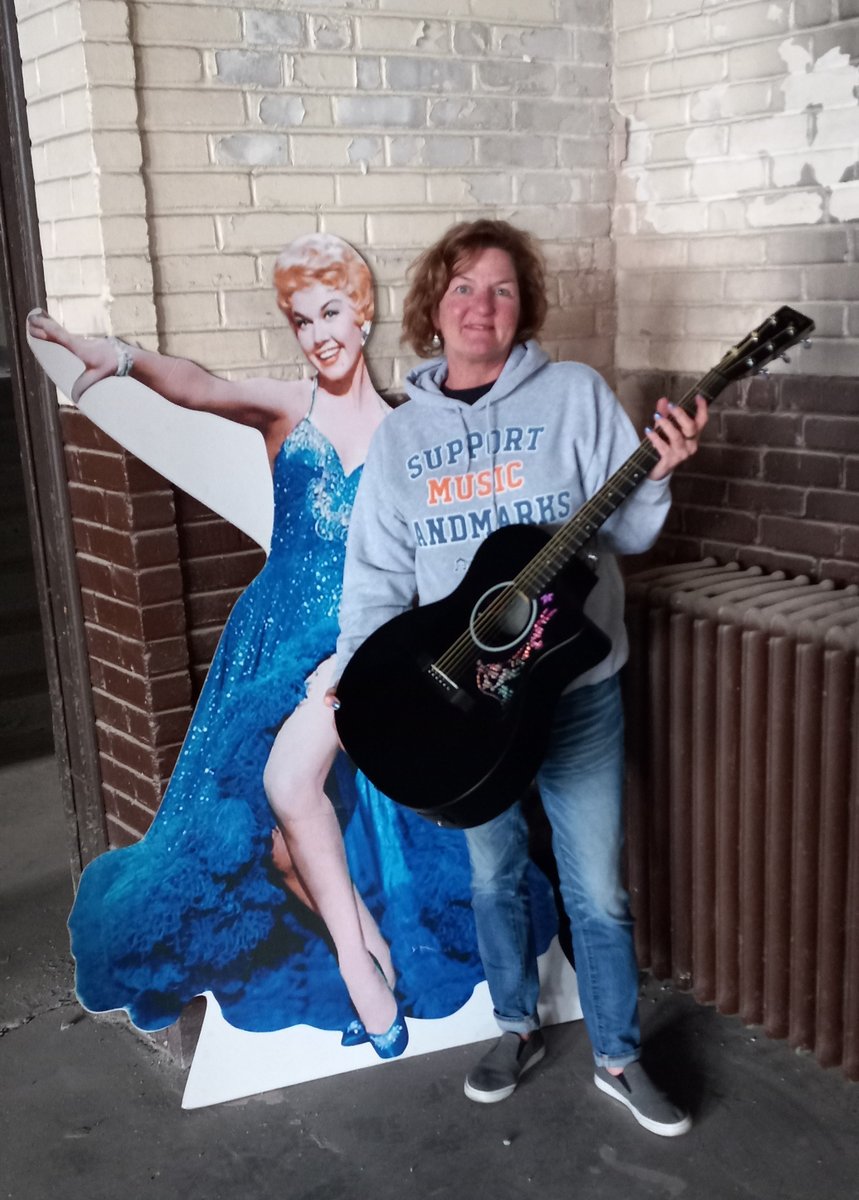 Michelle Miller, @DuluthArmory Fundraising Director wears her support for #musiclandmarks as she poses w/ #DorisDay who performed there in 1949! 🎙️🎶⭐️ #Duluth #Armory was featured in our inaugural #MusicLandmarksFest in Nov.! 🥳🎉 Get your gear at bonfire.com/musiclandmarks! 🪧🏠🎶