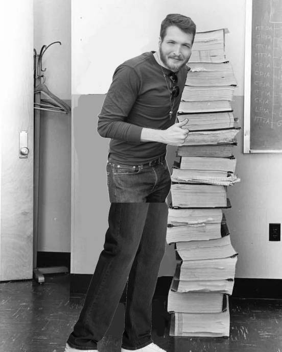 Zach Hadel standing next to a stack of code he written for the hit game Worm Odyssey