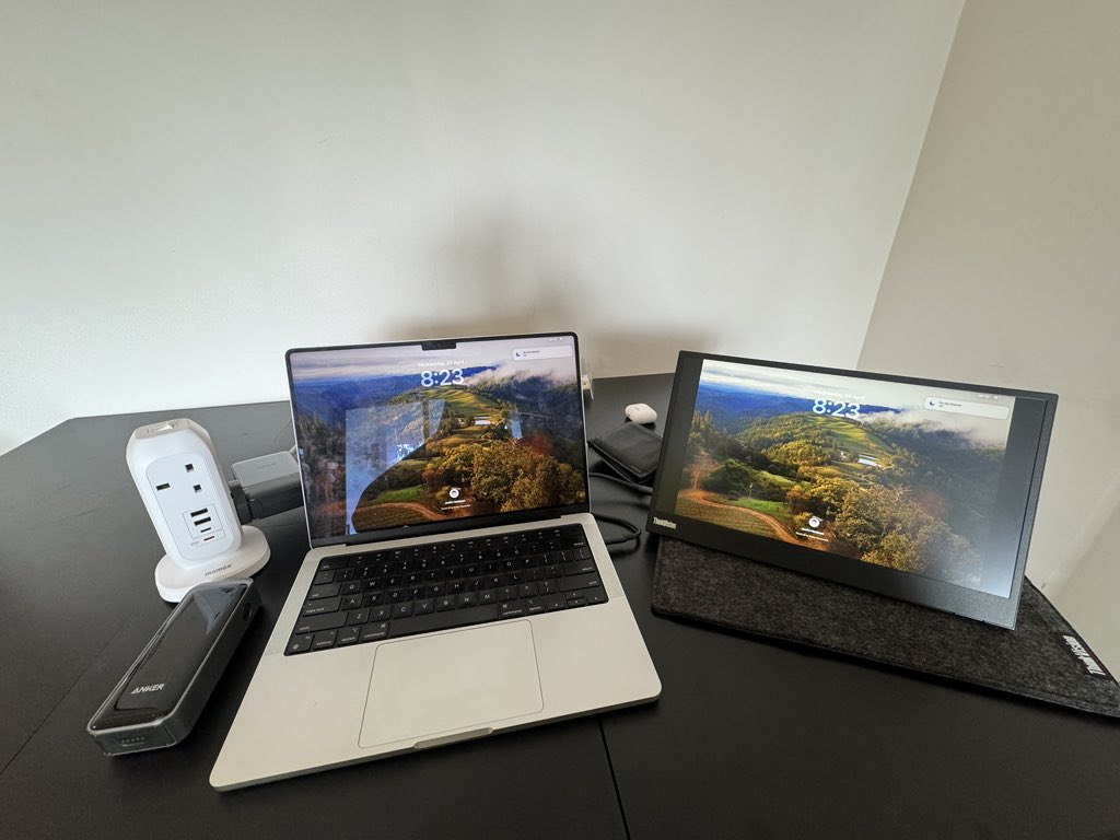 jahardman's tweet photo. I’ve spent a while crafting my #travelwork setup. You can never replicate an office at home but I like what I have
1.) MacBook Pro - this M1 MacBook has been the best computer I’ve ever used. Heavier than the air but so reliable
2.) Lenovo portable display. A must for extra screen real estate
3.) power “strip”. My wife got me into doing this - means only having to bring one adaptor.
4. Power bank - can charge phone at night by bedside without having to locate switch and bring another adaptor