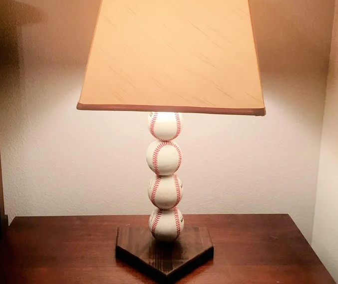 danielt391's tweet photo. DIY Baseball Lamp

This DIY baseball lamp project provides a step-by-step guide on how to create your own baseball-themed lamp for a man cave or a baseball player's room.

The first step involves finding or cutting a piece of wood into an 8" x 8" square, representing the base of the lamp, which resembles a home plate. The size of the home plate can be adjusted as long as the specified guidelines are followed - back of the home plate equals x, each side equals x/2, and the two remaining sides set at a 45-degree angle until intersection, with the standard size being 17" x 8.5" x 12".

After cutting out the home plate shape, it is crucial to sand to the lines accurately using a variety of sanding tools such as a disc sander, drum sander, or a hand sander. This step ensures a smooth finish for the lamp's base.

Marking the center of the baseballs and measuring the lamp rod width are essential for aligning the baseballs correctly on the lamp. The baseballs are then secured onto the threaded rod with lock nuts and washers provided in the lamp kit.

Drilling a hole through the center of the home plate and the baseball lamp rod allows for the electrical wiring to pass through smoothly. It is important to ensure the rod fits securely into the base to support the lamp.

Further steps involve sanding and finishing the wooden base to achieve a polished look. Concealing the lamp wire underneath the base plate and attaching the lamp rod securely complete the assembly process.

Testing the lamp to ensure it functions properly before finalizing the assembly with the remaining hardware and a lamp shade is recommended. The use of hot glue to secure the wire in place provides a quick and effective solution.

In conclusion, this DIY baseball lamp project offers a creative way to incorporate a baseball theme into home decor. By following the detailed instructions provided, anyone can successfully create their own unique baseball lamp for a personalized touch to their living space.