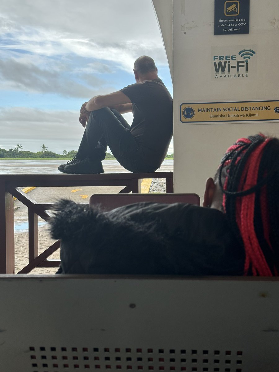 This man is sitting on the railings, awaiting to board his flight at the Malindi International Airport. You are not likely to ever see Africans doing so. Also no one told him anything.