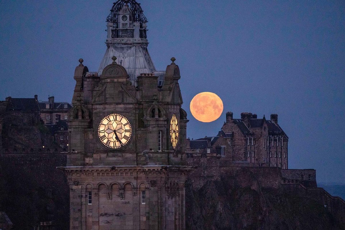 The full moon, known as the Pink Moon in April, sets behind the Balmoral Clock and Edinburgh Castle #moon #fullmoon #pinkmoon #spring #thebalmoral #clock #moonset #edinburghcastle #edinburgh #Scotland