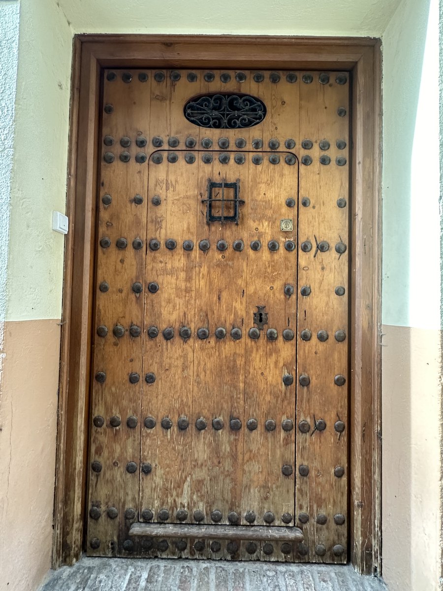 Sturdy wooden door in Malaga, Spain, with wicket door
#woodensday 
#doors