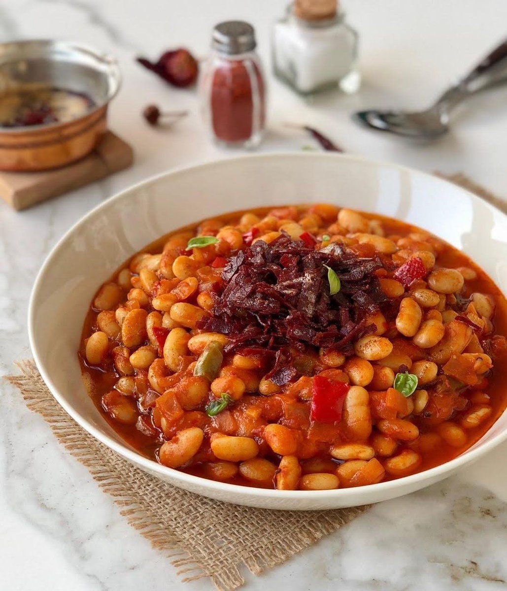 White beans cooked with tomato sauce, onions, and spices are enhanced with pastırma (pastrami), making Kuru Fasulye a deliciously satisfying dish. #TurkishCuisine

📸 IG: mujganyurtseven