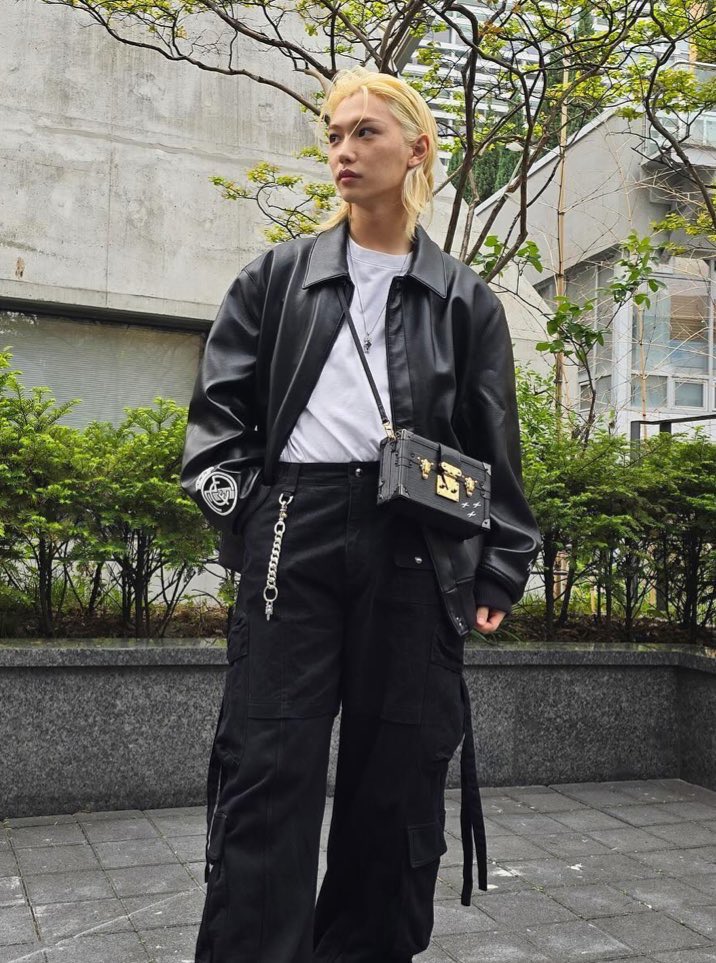 the slicked back blonde hair, the leather jacket white tee combo, the streetwear pants with the chain, his little louis bag and couple necklace. felix ate this look up