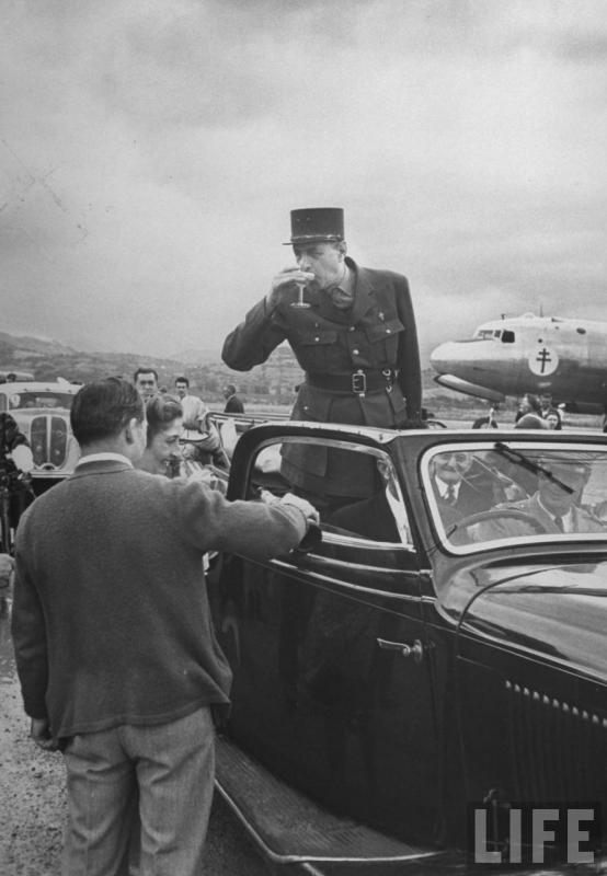Le général Charles de Gaulle déguste une coupe de champagne.