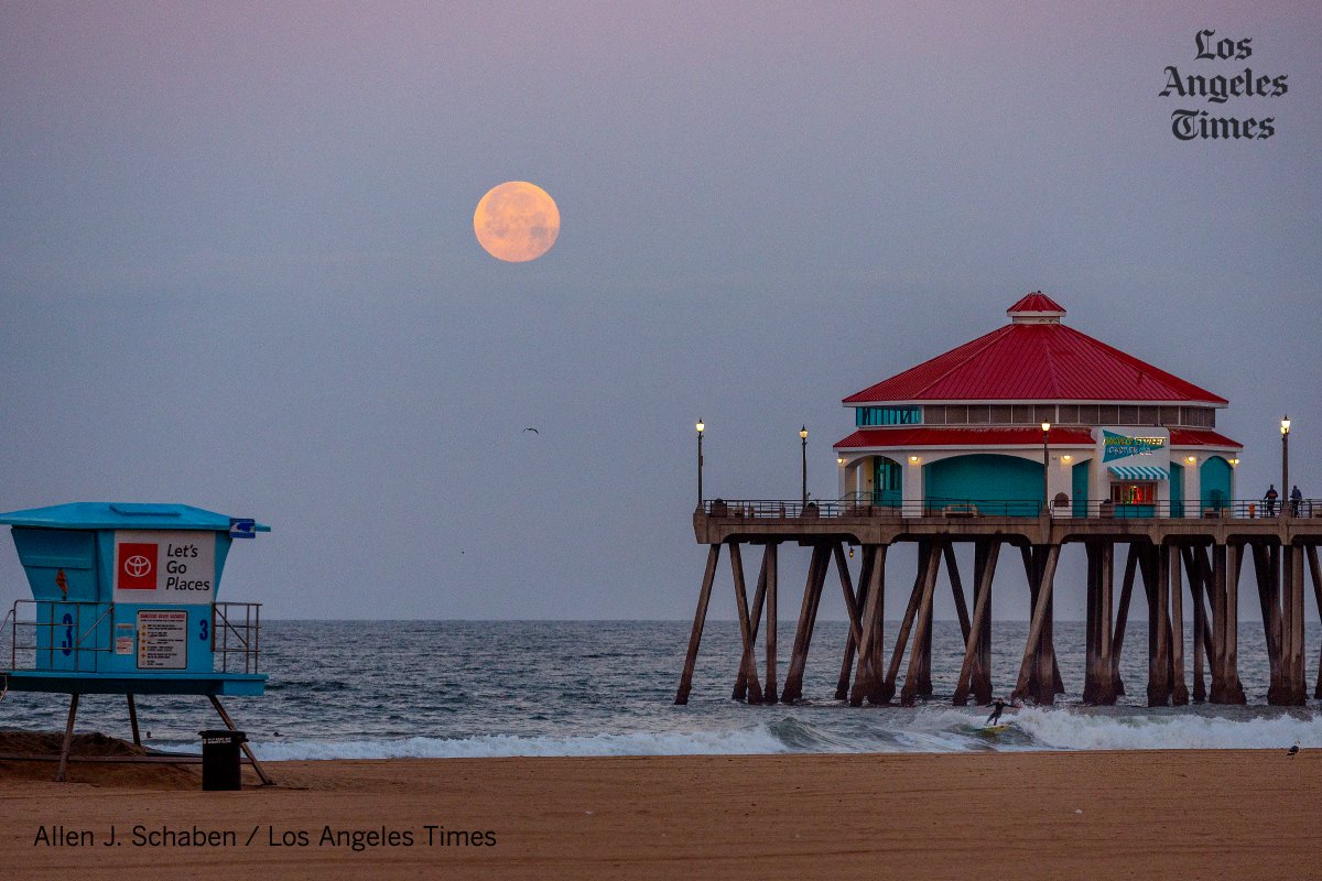 Surfers and pier walkers are treated to an early morning view of the full Pink Moon setting over the Huntington Beach Pier @latimes @latimesphotos #PinkMoon