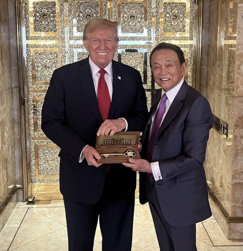 Trump, pretending to be president, gives former PM Taro Aso of Japan, the “key” to the WH. Always the clown.