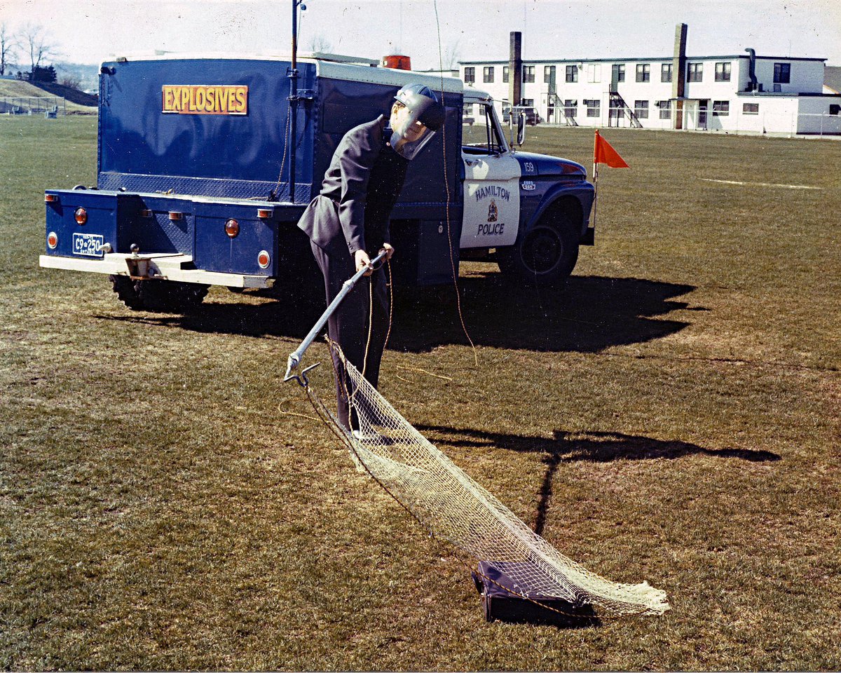 Explosives Ordinance Disposal (EOD) used to be done in a tailored suit, a face shield and a net. Now EOD is part of the Emergency Response Unit. Photo at Eastwood Park ca 1970. We still have that truck!#HPSArchives #PoliceHistory #HamOnt #HamOntHistory #HPSHistory #HPSMuseum