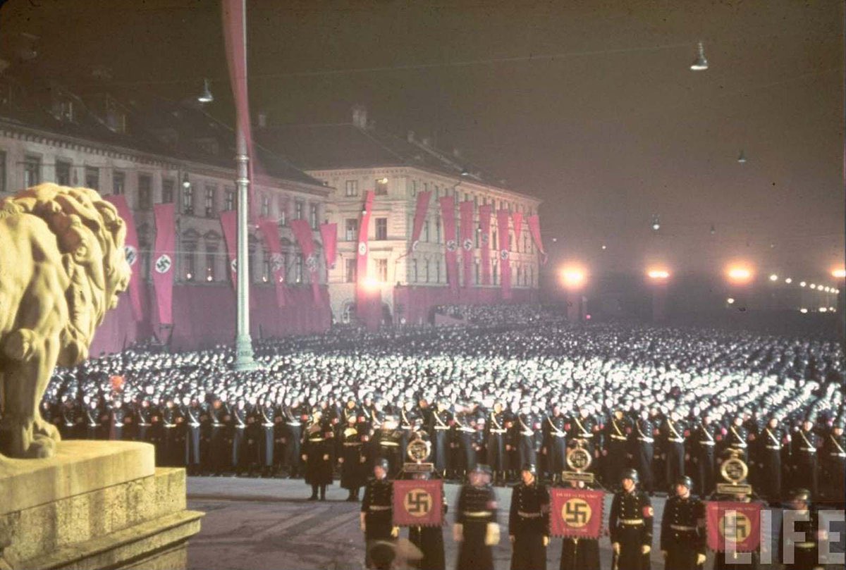 Photograph taken in Munich, Germany, 1938, shows the annual midnight swearing-in of Nazi SS troops. Candidates for SS officer positions were required to present certified evidence of Aryan lineage tracing back to the 1750s. Adolf Hitler's personal bodyguard regiment members…