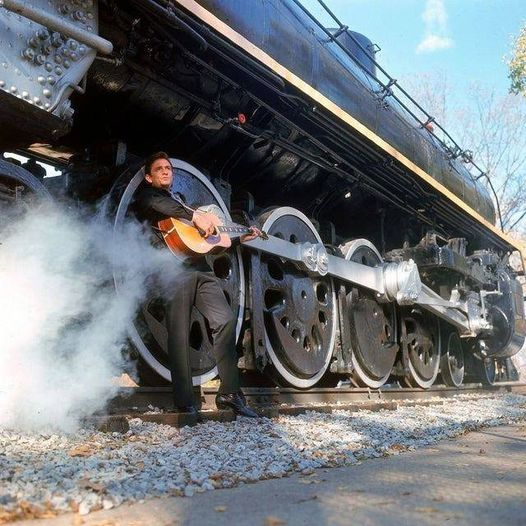 Johnny Cash in front of a locomotive. Photo by Michael Rougier.